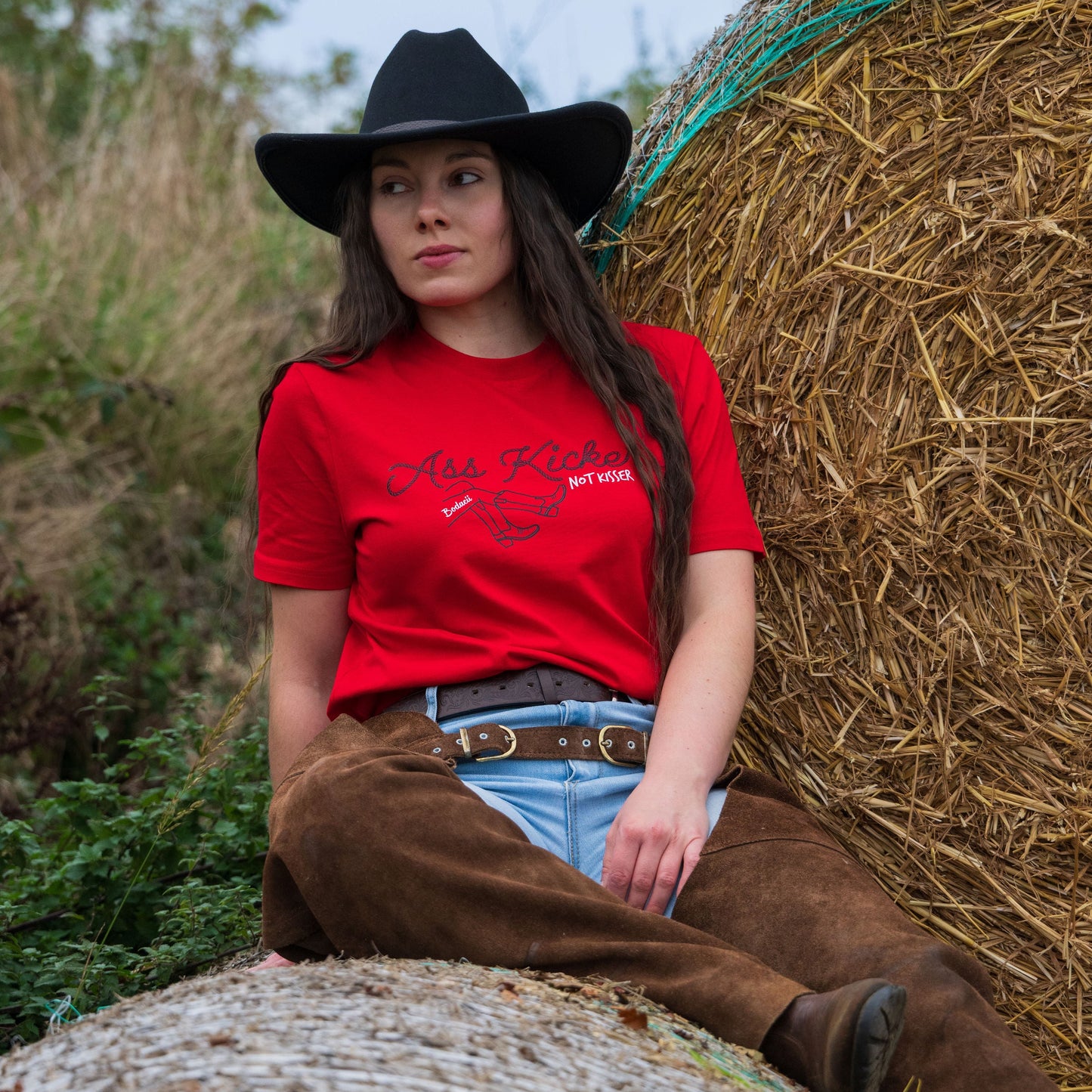bold cowgirl sat on bales, western fashion