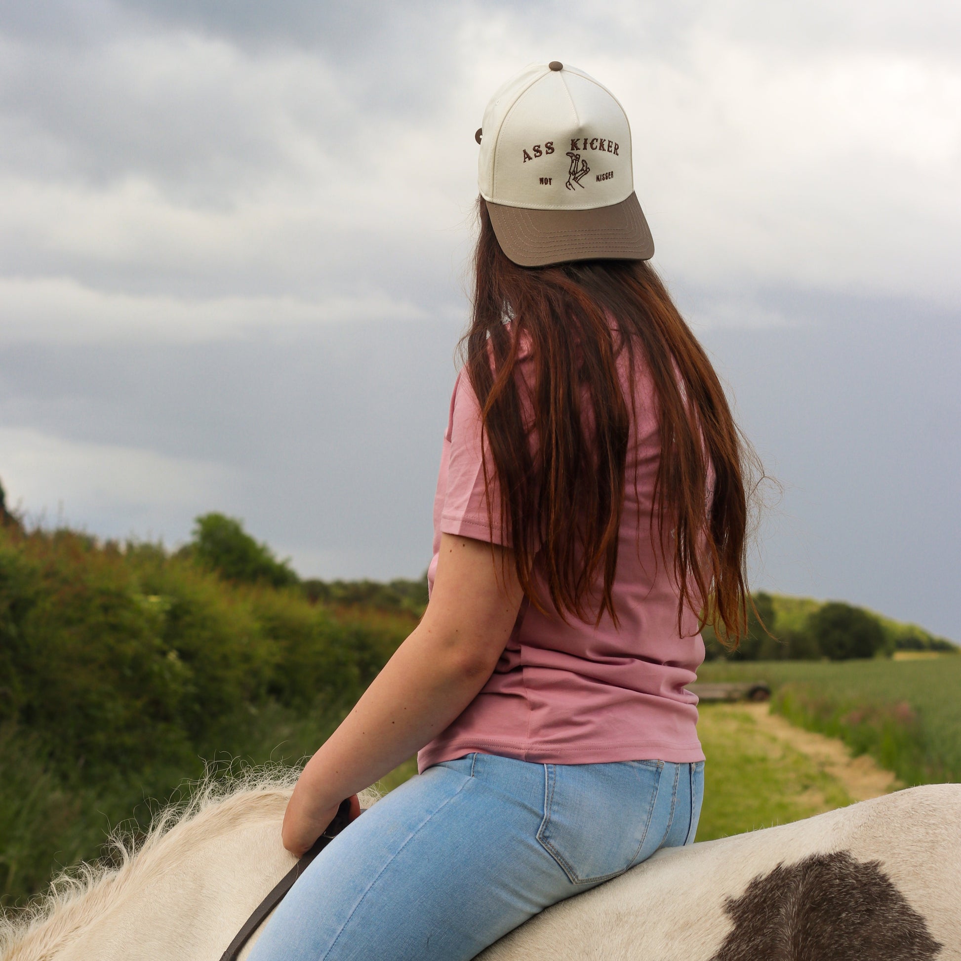 cowgirl riding horse, trucker cap