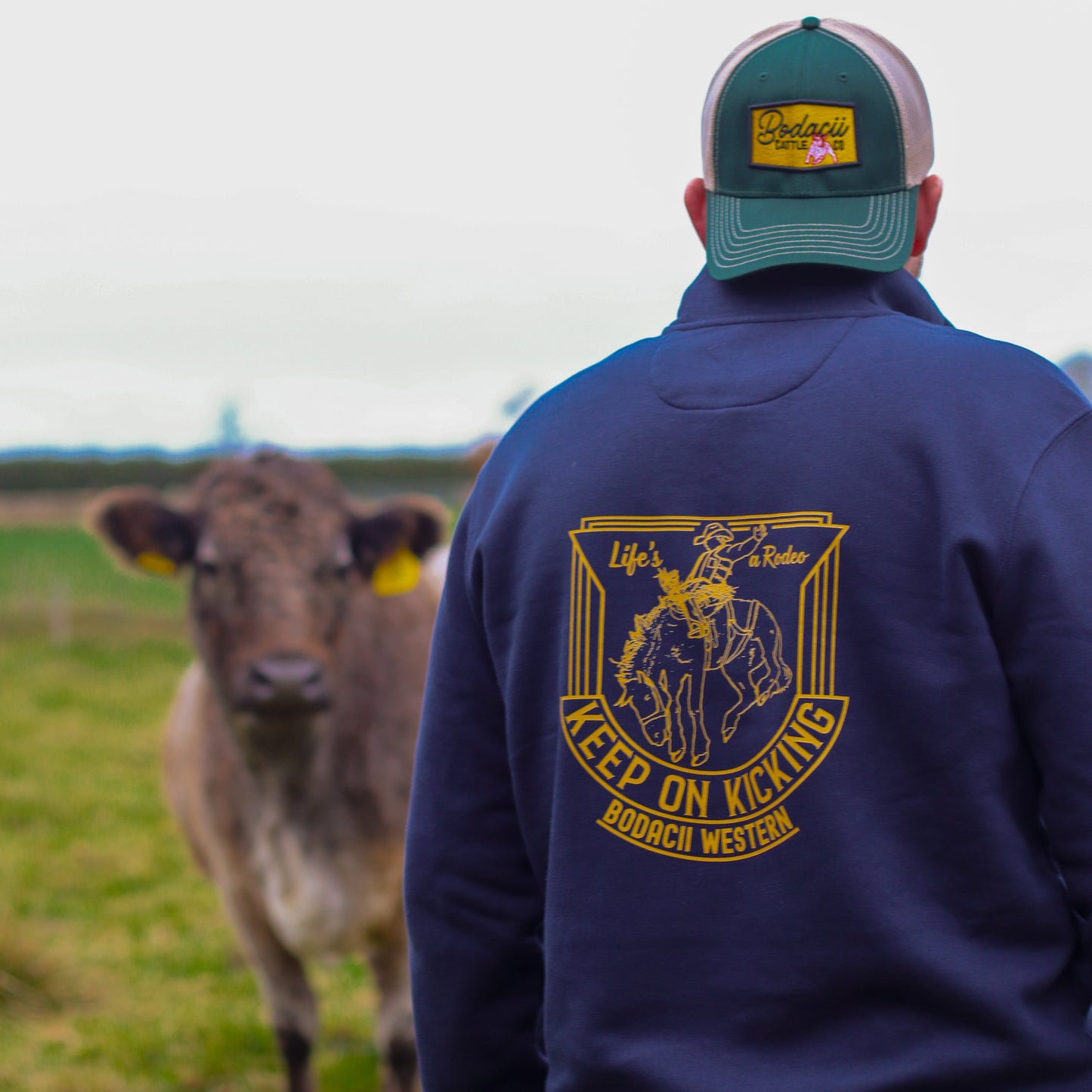 cowboy wearing quarter zip on cattle ranch