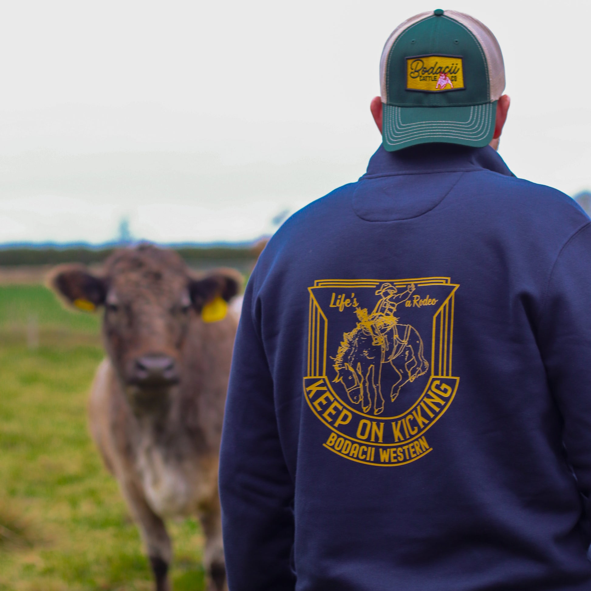 cowboy wearing quarter zip on cattle ranch
