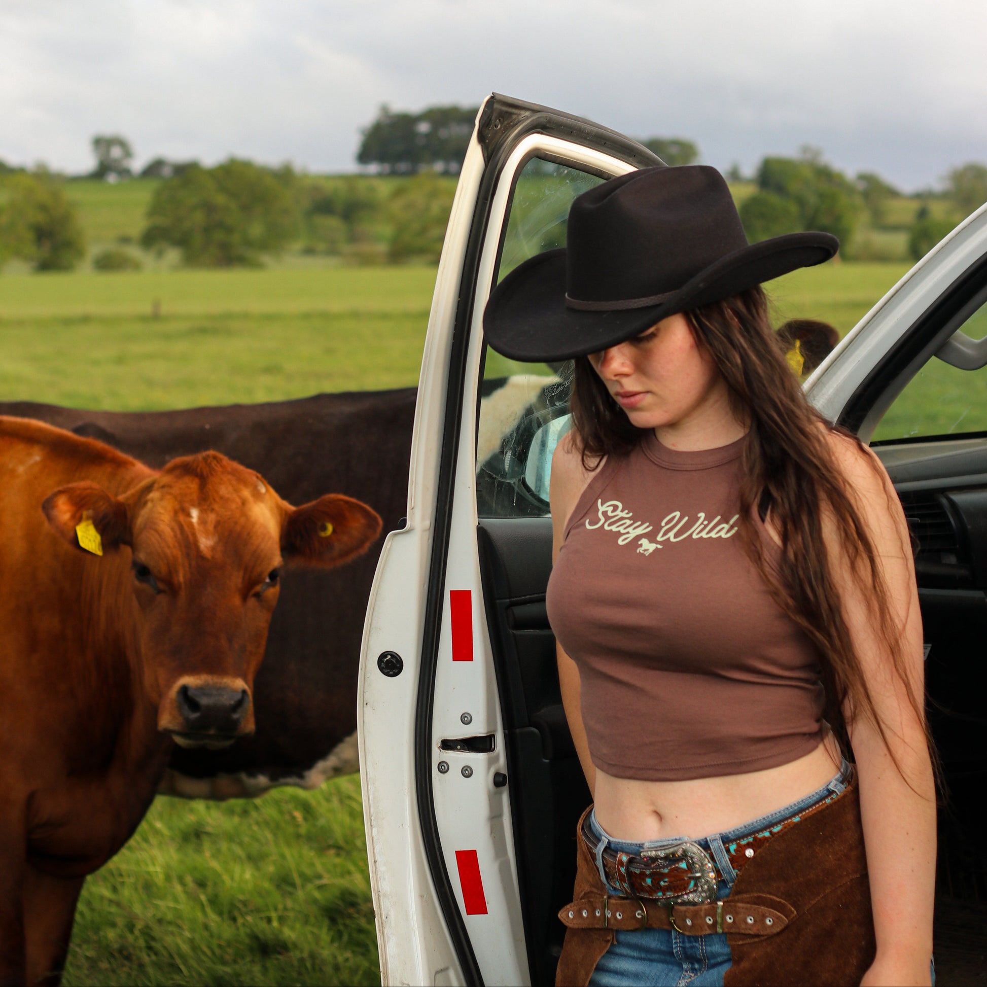 cowgirl wearing summer tank top, featuring 'stay wild' with a horse design