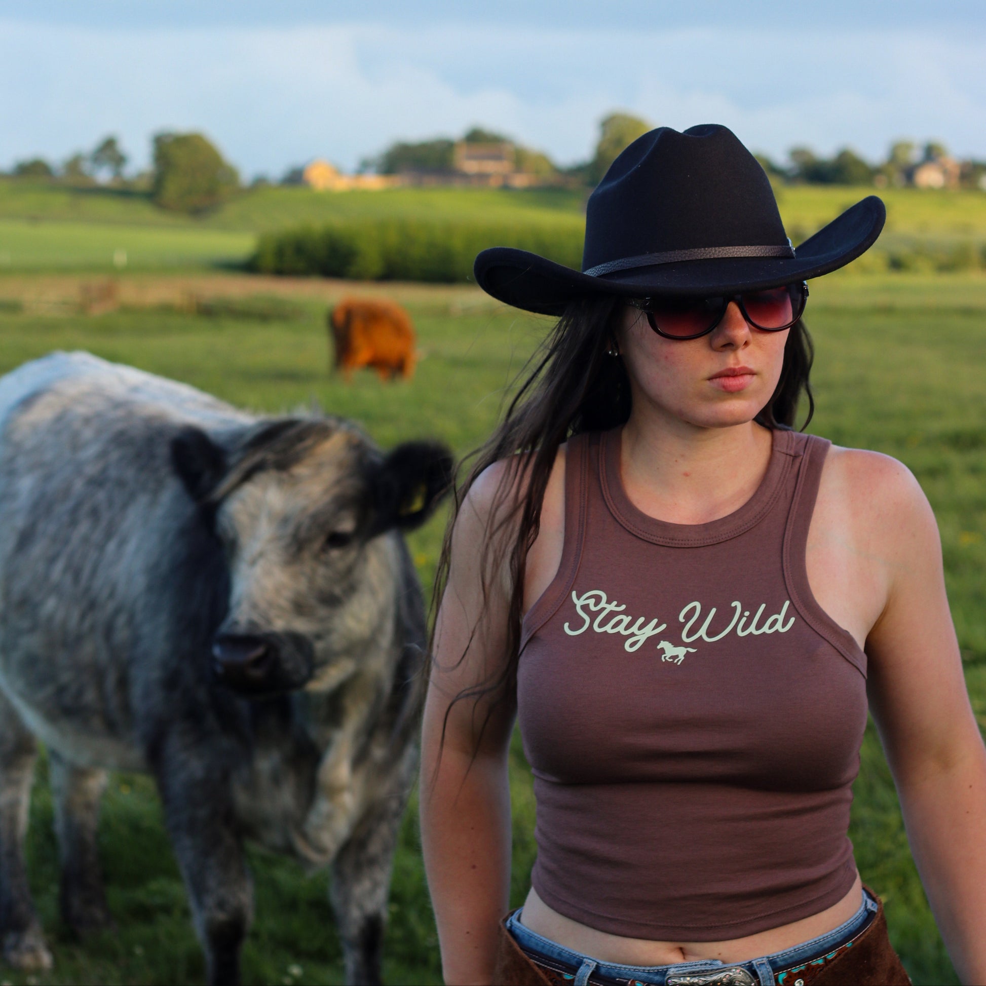cowgirl wearing summer tank top, featuring 'stay wild' with a horse design