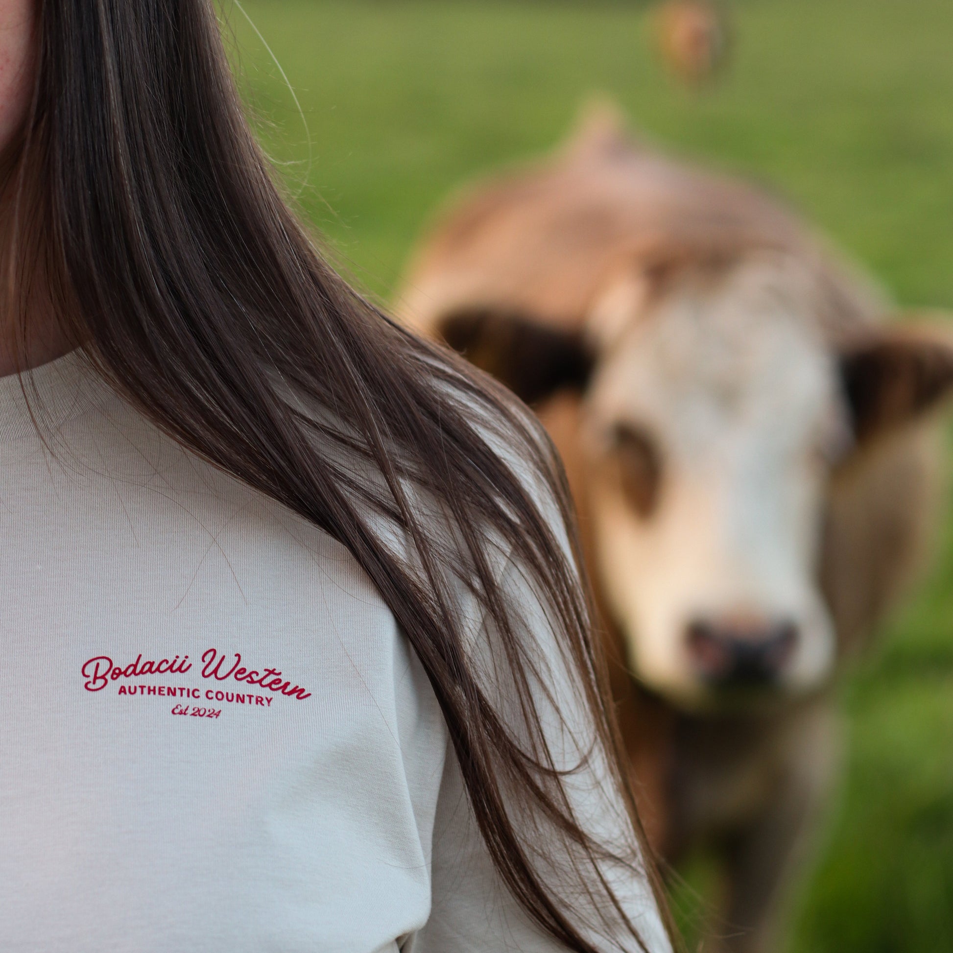 cowgirl wearing roping western tshirt with cattle and sunset